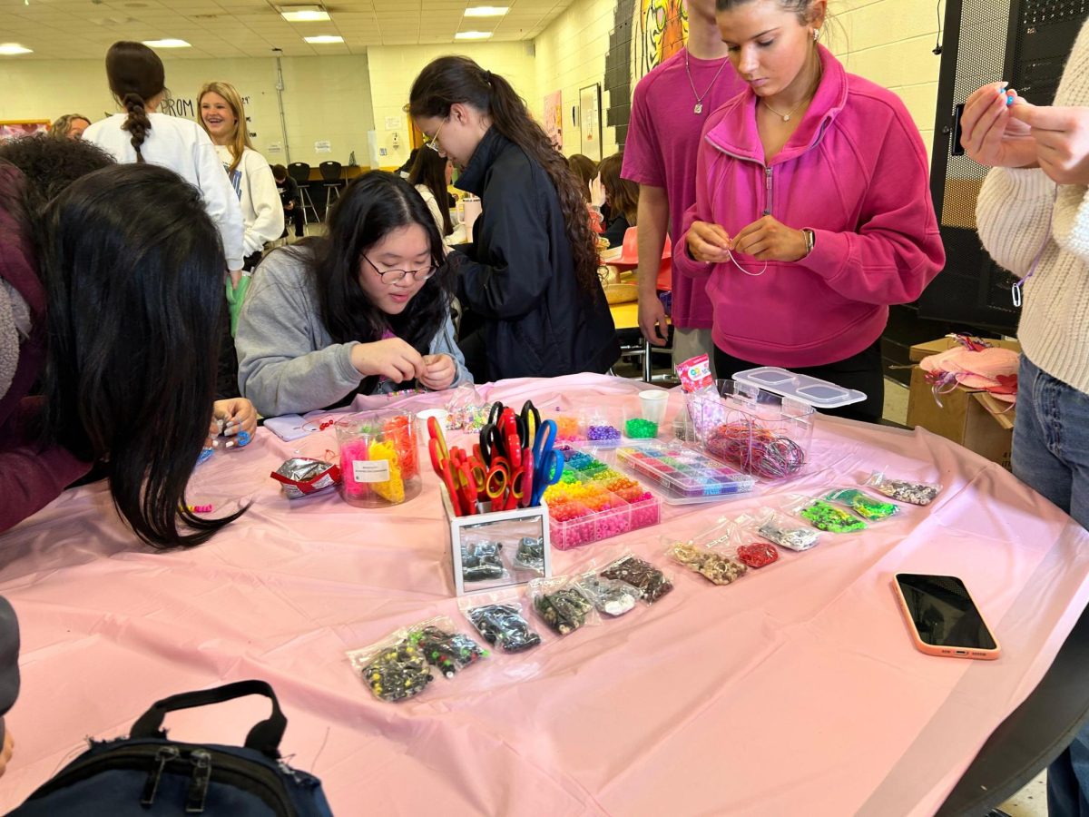 Students making bracelets at a fun lunch