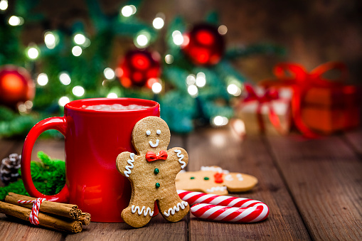 Christmas backgrounds: gingerbread cookies and hot chocolate shot on rustic wooden table.