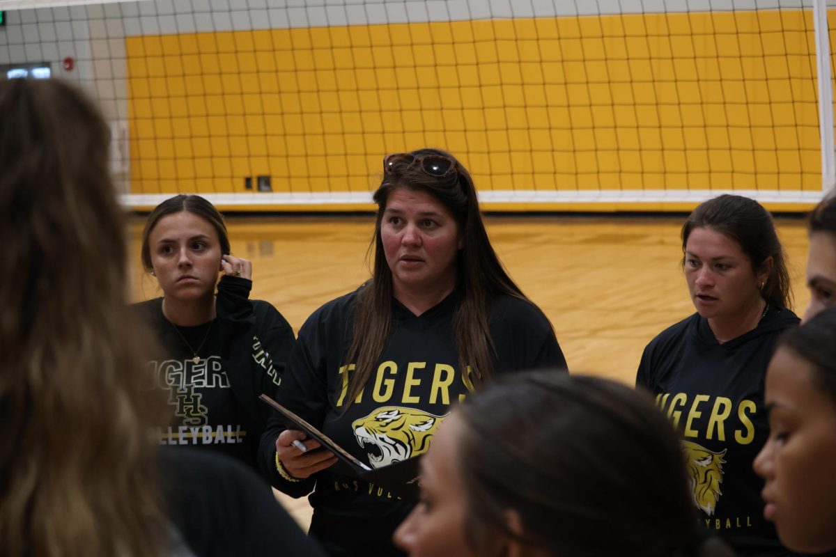 Coach Cross in huddle with the varsity players.